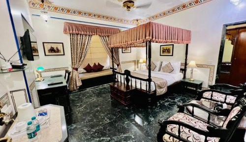 Royal Deluxe Room: Free pickup from train or bus station on arrival. Enjoy daily Rajasthani dance & music (7PM–9 PM), swimming pool, kids stay free, and a dedicated travel desk to assist with local sightseeing tours, intercity travel and activities